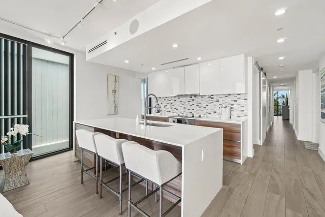 a kitchen with stainless steel appliances kitchen island granite countertop a table chairs sink and cabinets