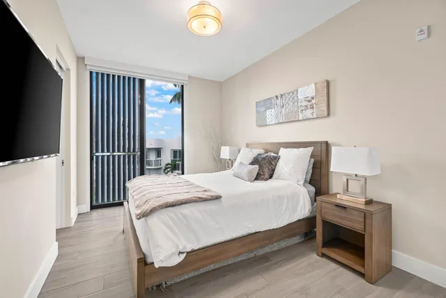 a bedroom with a bed and a flat tv screen on dresser