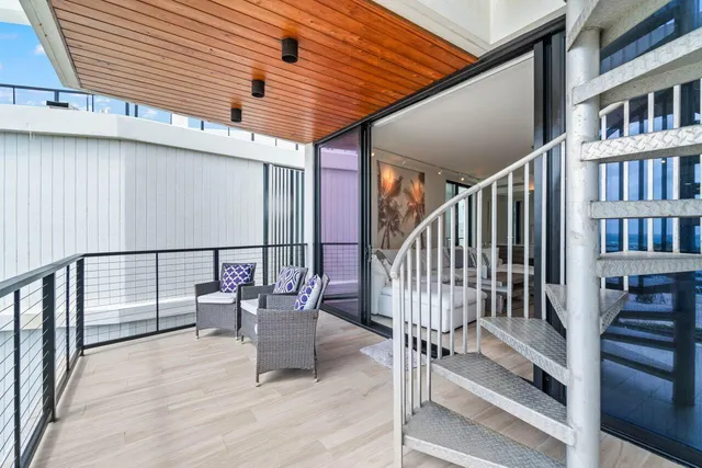 a balcony with chairs and wooden floor