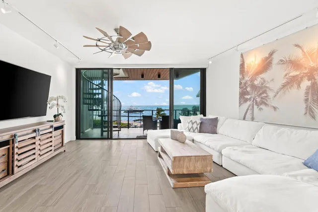 a living room with furniture a flat screen tv and a floor to ceiling window