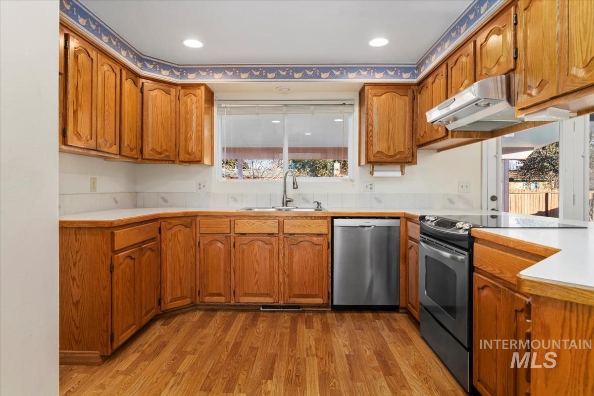 3850 Rugby Drive Boise, ID 83704 - Photo 12 of 44 Kitchen featuring light countertops, appliances with stainless steel finishes, brown cabinetry, and recessed lighting