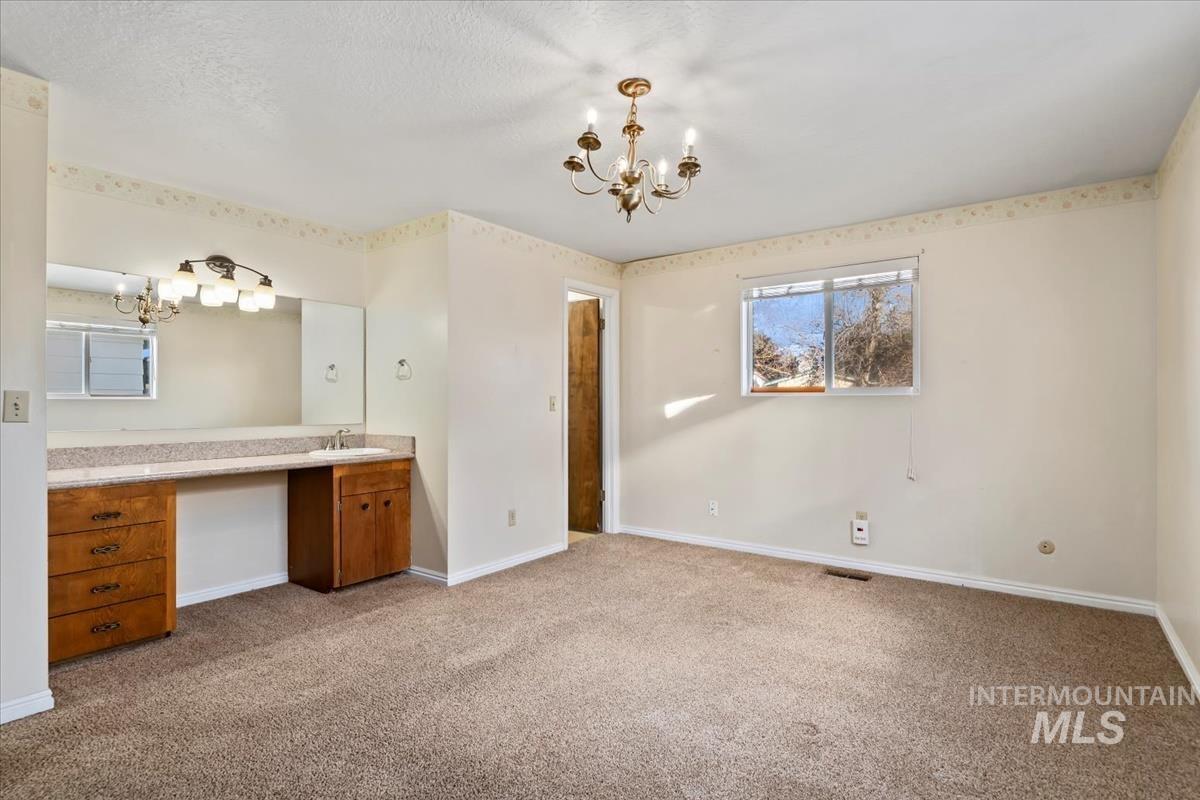3850 Rugby Drive Boise, ID 83704 - Photo 23 of 44 Bathroom with a chandelier, light colored carpet, and vanity