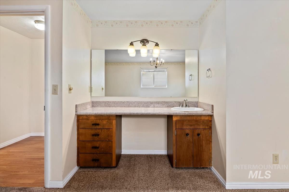 3850 Rugby Drive Boise, ID 83704 - Photo 24 of 44 Bathroom featuring vanity, dark carpet, and a chandelier