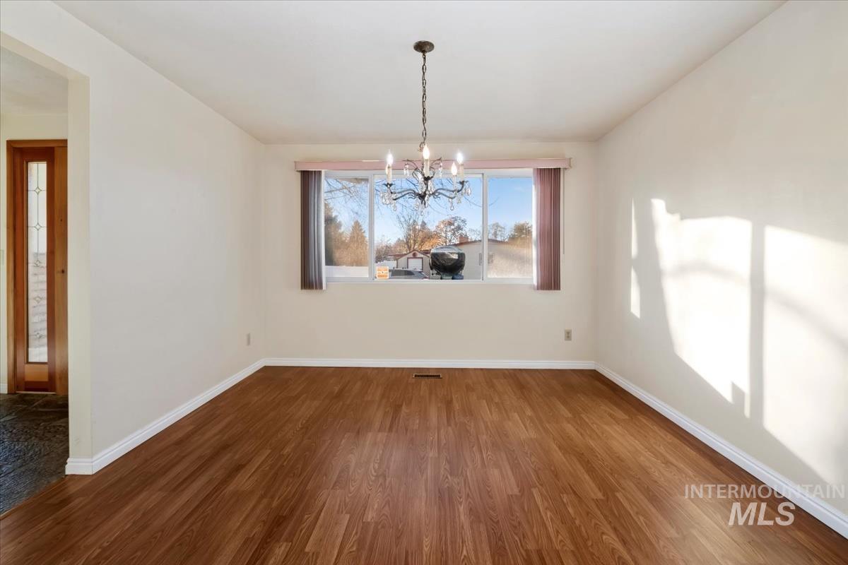 3850 Rugby Drive Boise, ID 83704 - Photo 9 of 44 Unfurnished dining area featuring dark wood-type flooring and a chandelier