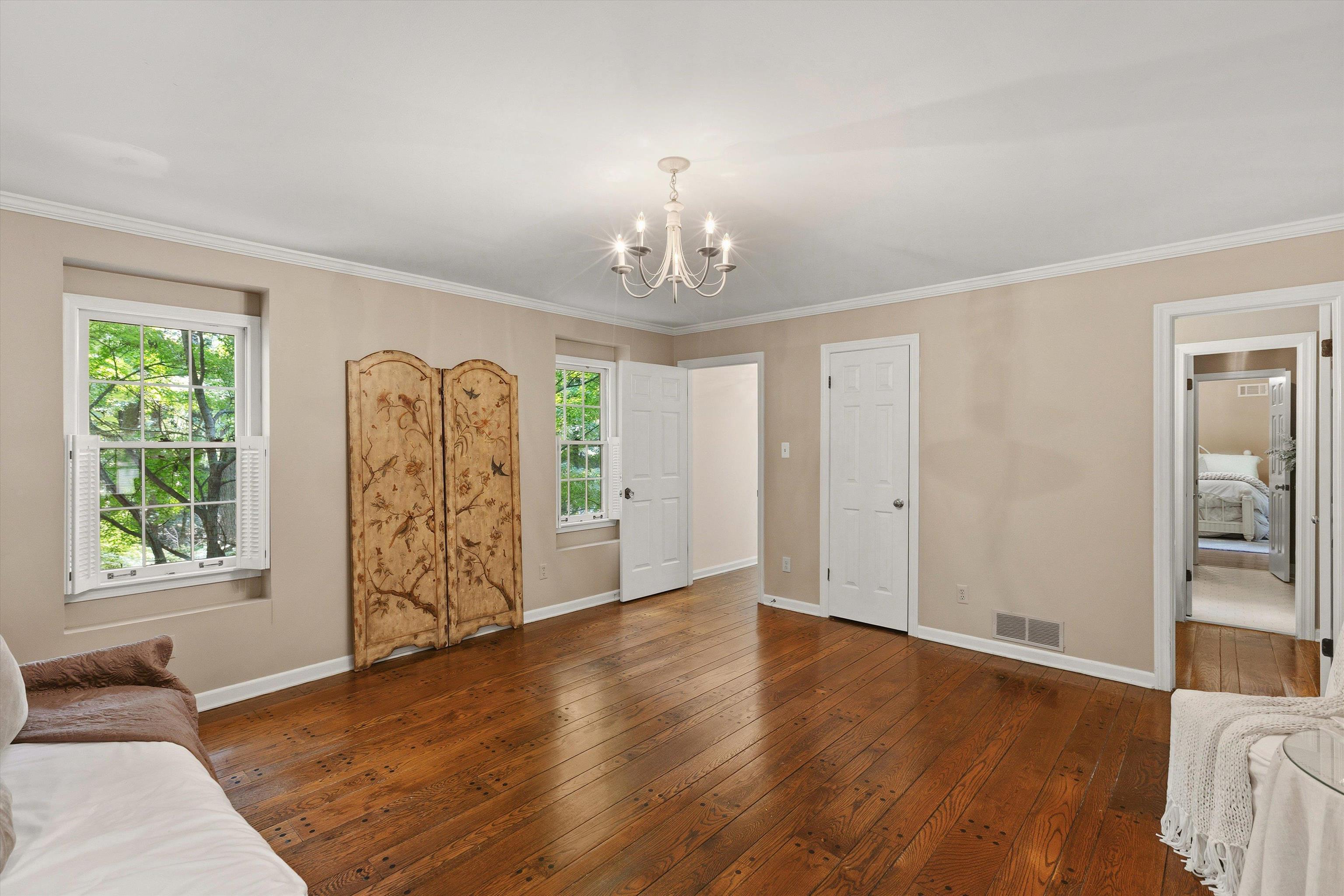 5828 Haymarket Road Memphis, TN 38120 - Photo 37 of 40 Spacious room featuring wood-finish flooring, two windows with white shutters, a white ceiling light fixture, and white trim