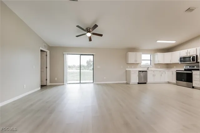 a view of a kitchen with a sink dishwasher cabinets and a kitchen
