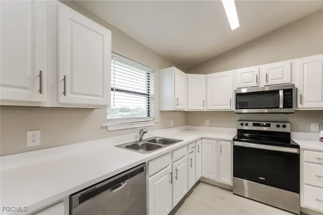 a kitchen with white cabinets and black appliances