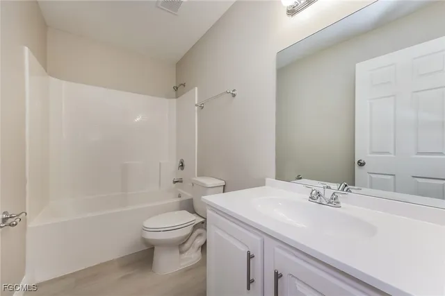 a bathroom with a granite countertop sink a toilet and a large mirror