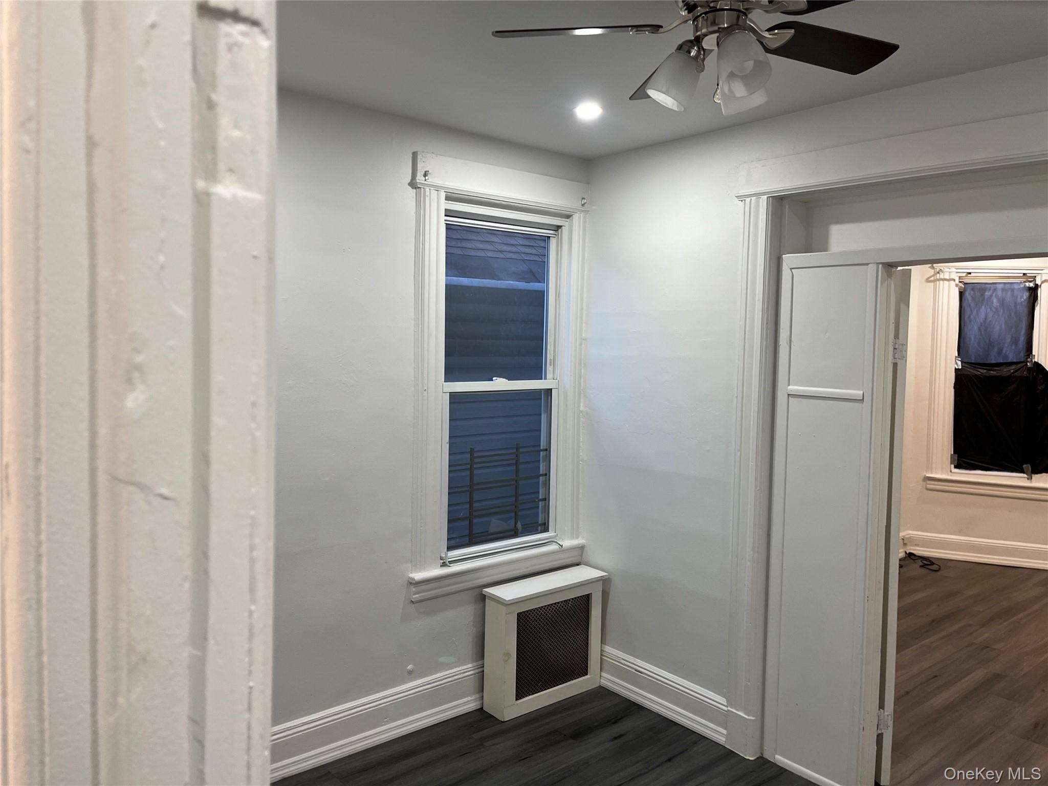 95-29 112th Street, Unit 2 Queens, NY 11419 - Photo 4 of 10 Detailed view of wood finished floors, a ceiling fan, and radiator