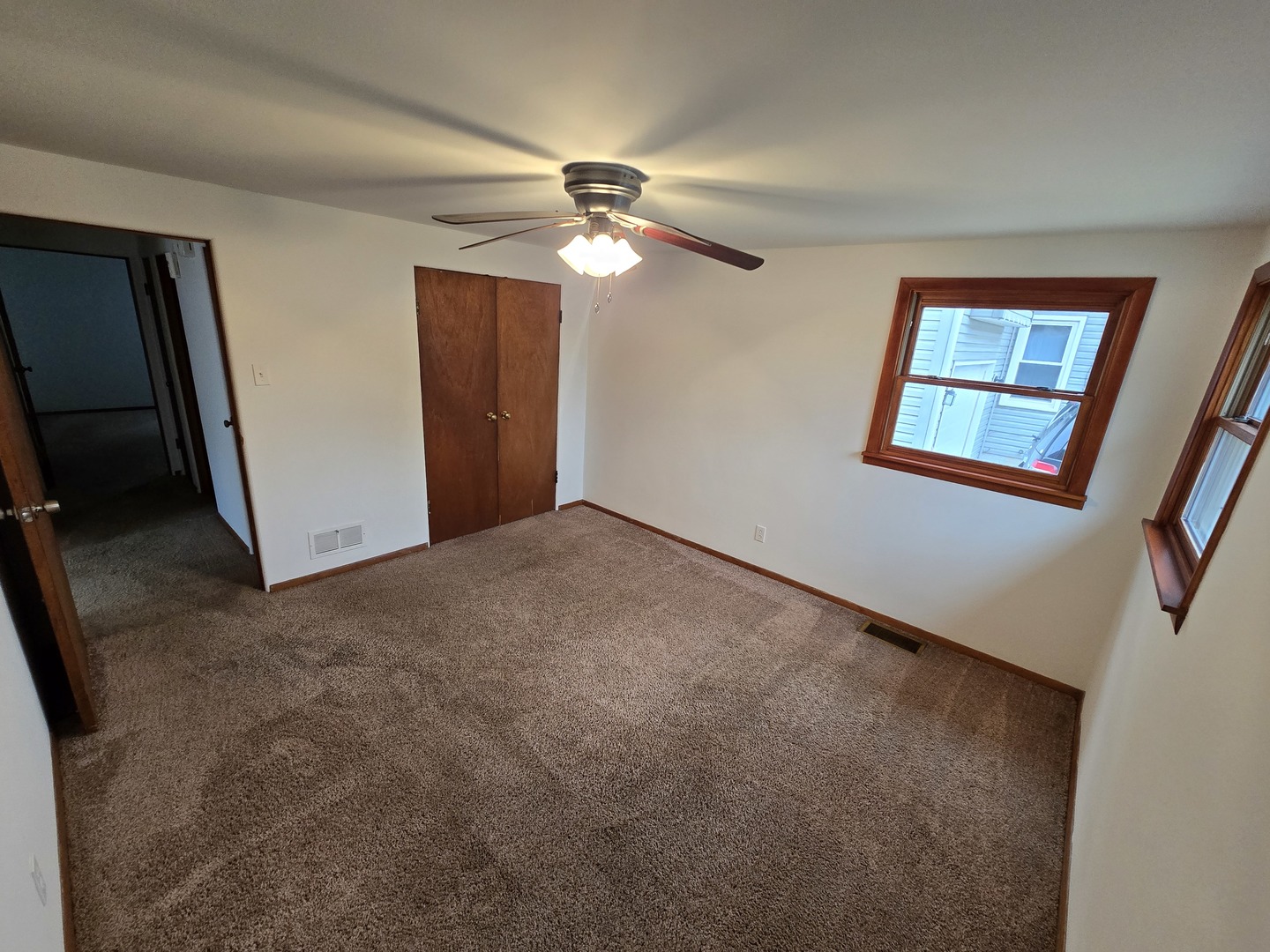 417 Stewart Avenue Woodstock, IL 60098 - Photo 14 of 22 an empty room with windows and fan