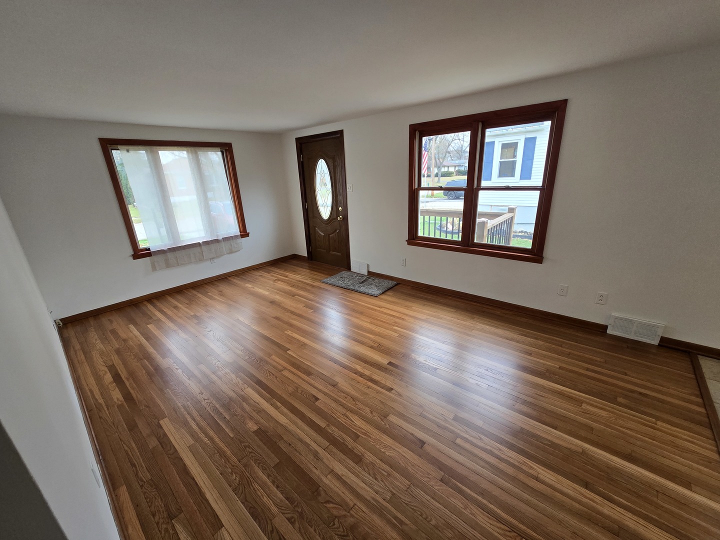 417 Stewart Avenue Woodstock, IL 60098 - Photo 5 of 22 a view of an empty room with wooden floor and a window