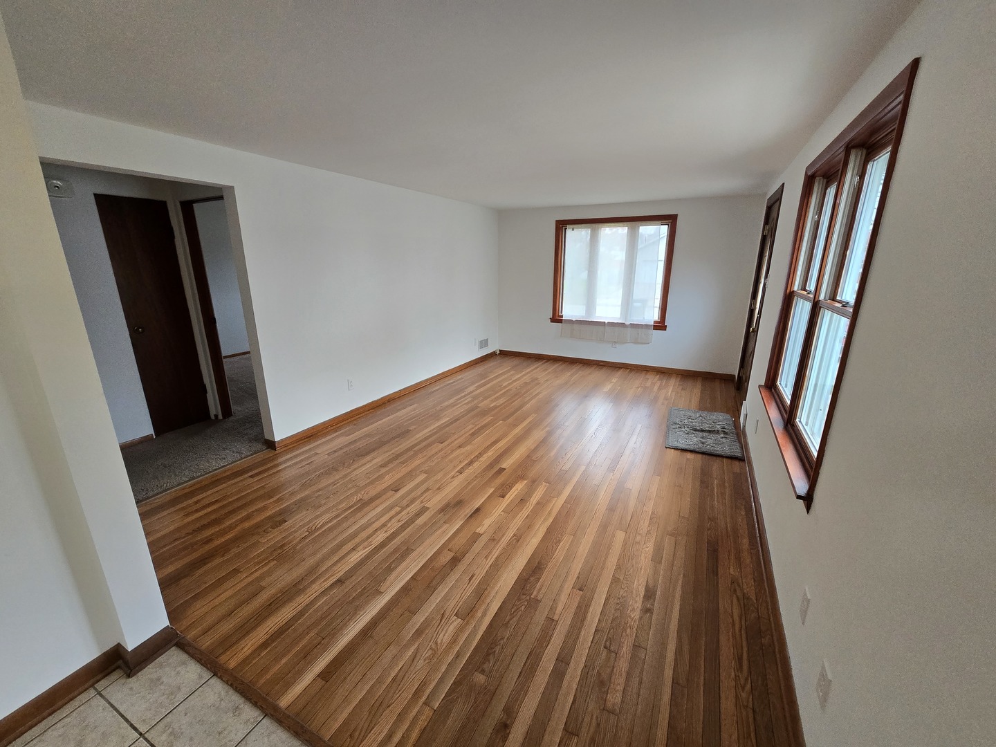 417 Stewart Avenue Woodstock, IL 60098 - Photo 6 of 22 a view of an empty room with wooden floor and a window
