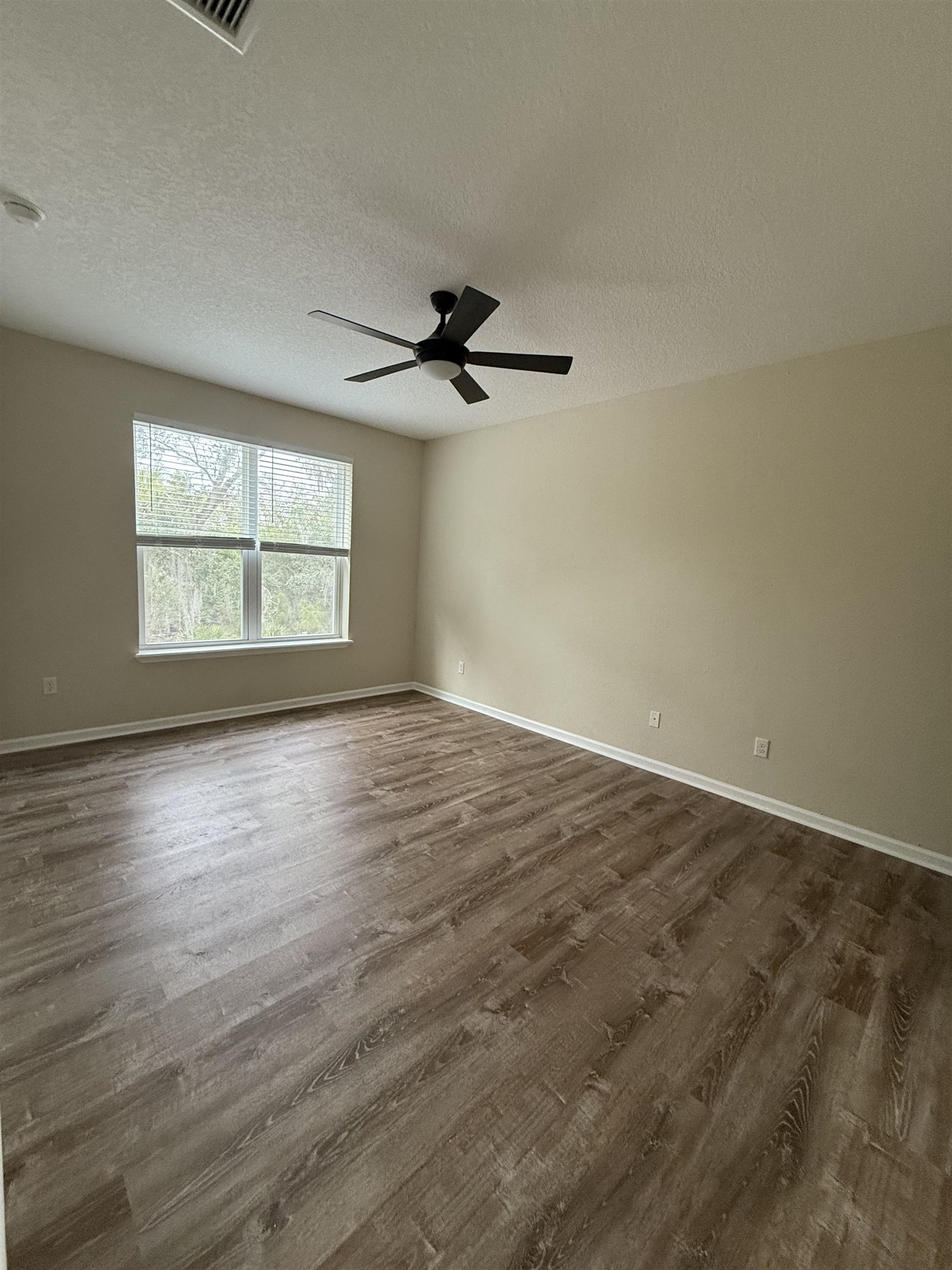 209 Leeward Island Drive St. Augustine, FL 32080 - Photo 5 of 22 an empty room with wooden floor and windows