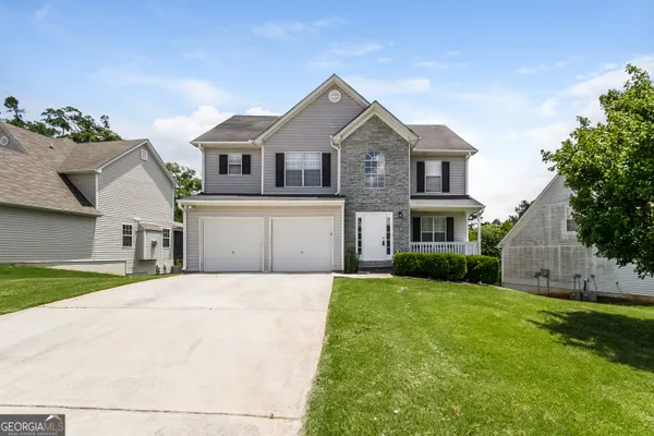a front view of a house with a yard and garage