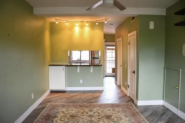 a view of a hallway with wooden floor and a living room