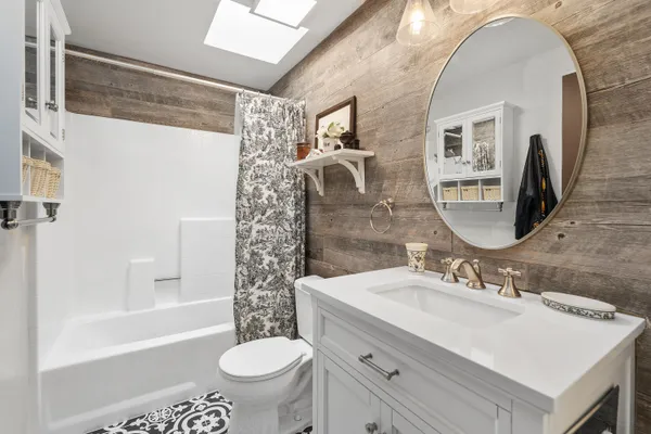 a bathroom with a sink toilet a mirror and shower