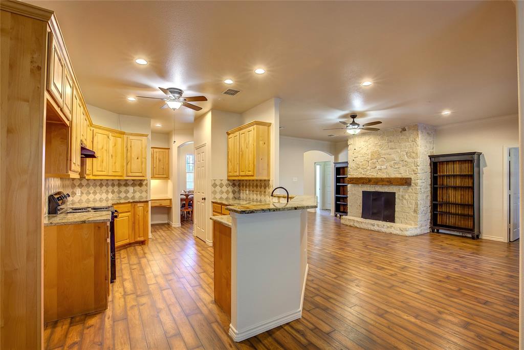 2617 Kirby Road Rowlett, TX 75088 - Photo 10 of 39 Kitchen featuring arched walkways, light stone countertops, a ceiling fan, stainless steel range with electric cooktop, and a peninsula