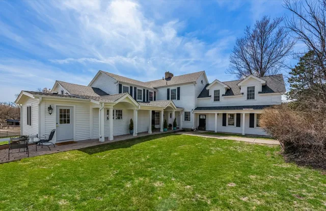 a front view of a house with a garden and trees