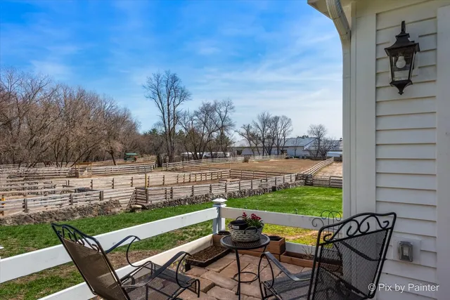 a view of yard with seating area and trees in the background
