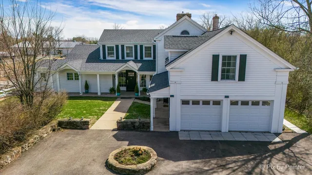 a aerial view of a house next to a big yard and large trees