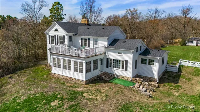 a view of a house with wooden deck and furniture