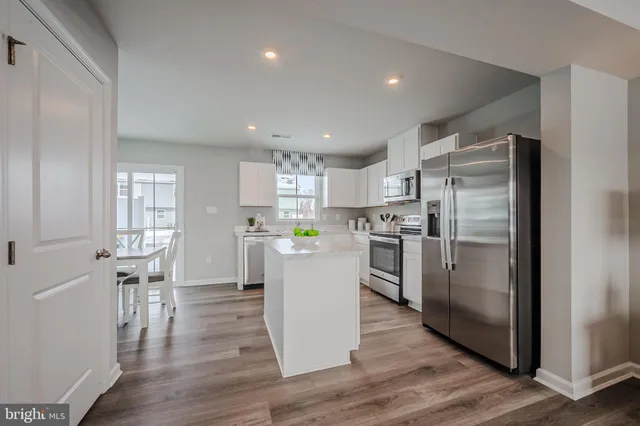a kitchen with a refrigerator a sink and a stove top oven