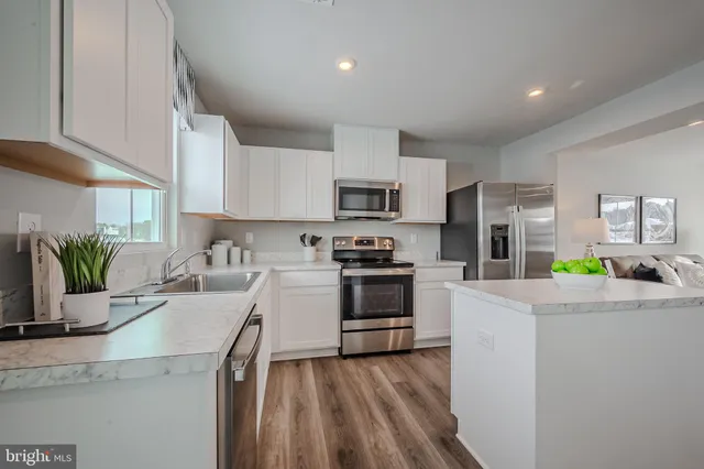 a kitchen with granite countertop a sink stove and refrigerator