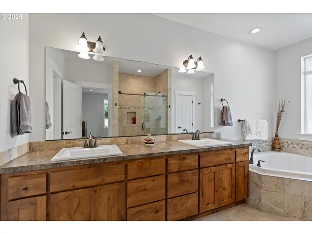 a bathroom with a granite countertop shower mirror and a bathtub