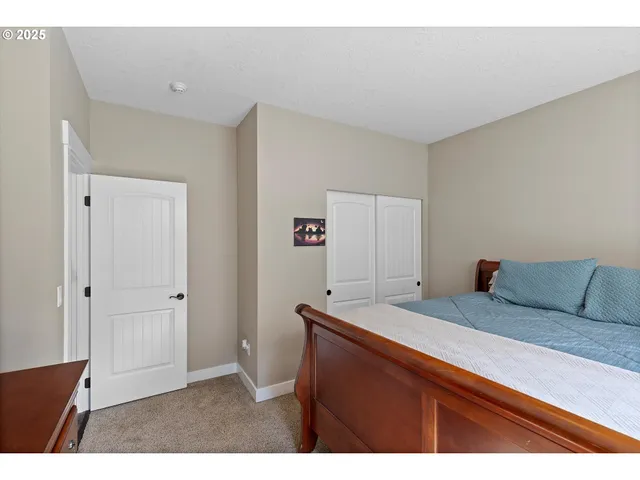 a bedroom with a bed and next to a window