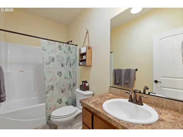 a bathroom with a granite countertop sink a toilet and a mirror