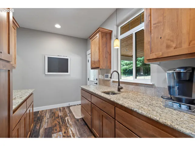 a kitchen with kitchen island granite countertop wooden cabinets a sink and a stove
