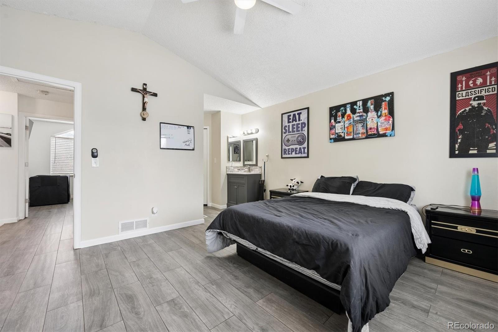 11688 East Cedar Avenue Aurora, CO 80012 - Photo 11 of 24 a bedroom with a bed and a chandelier