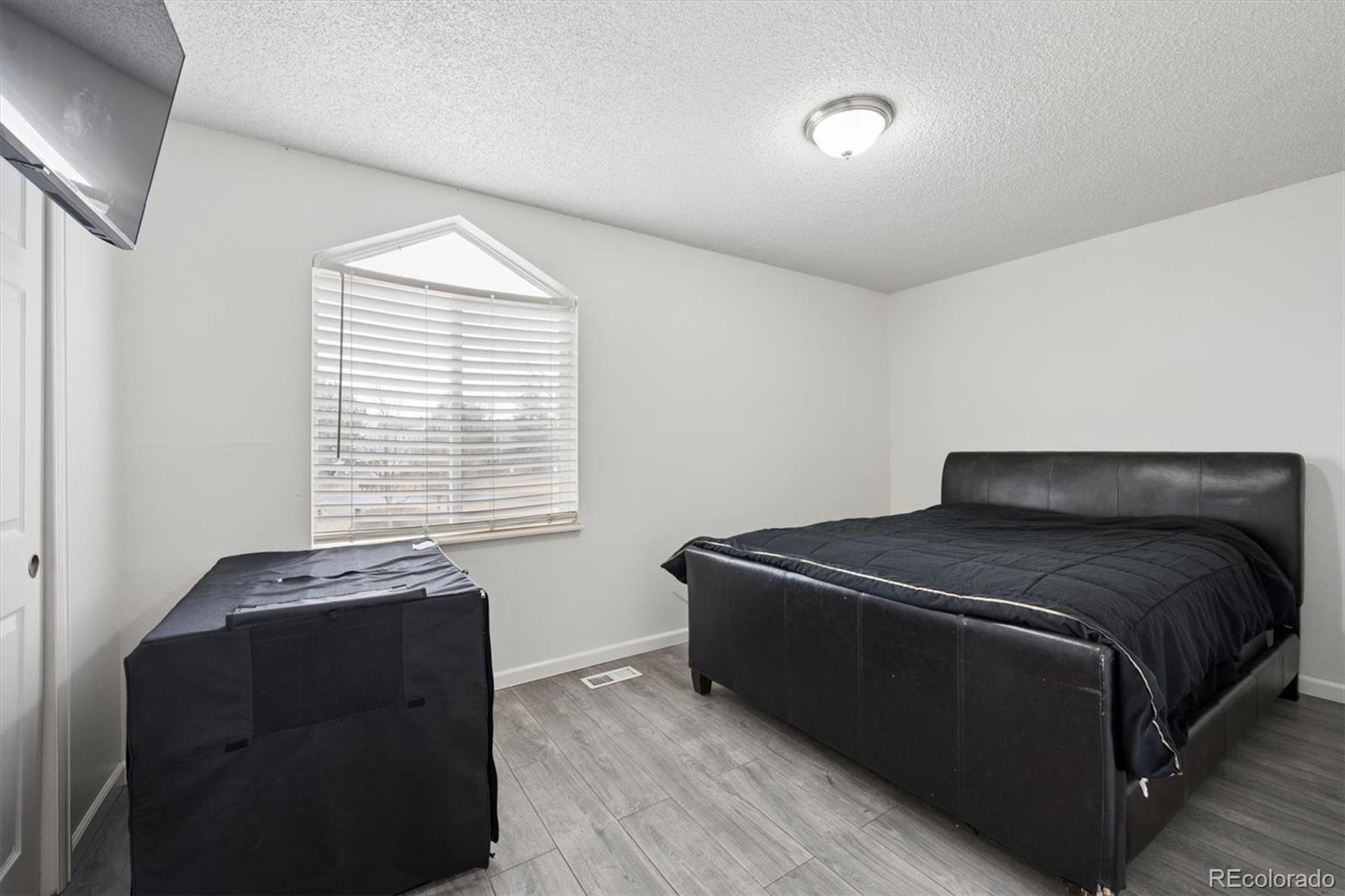 11688 East Cedar Avenue Aurora, CO 80012 - Photo 16 of 24 a bed sitting in a bedroom next to a window