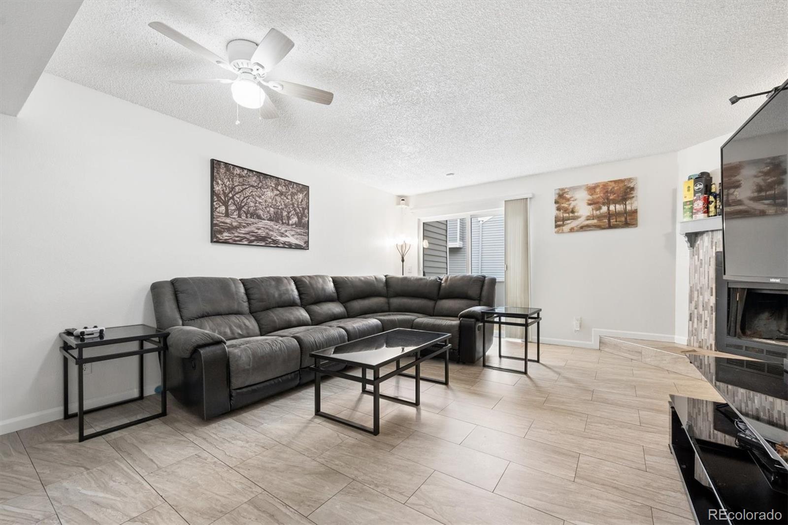 11688 East Cedar Avenue Aurora, CO 80012 - Photo 2 of 24 a living room with furniture a fireplace and a flat screen tv
