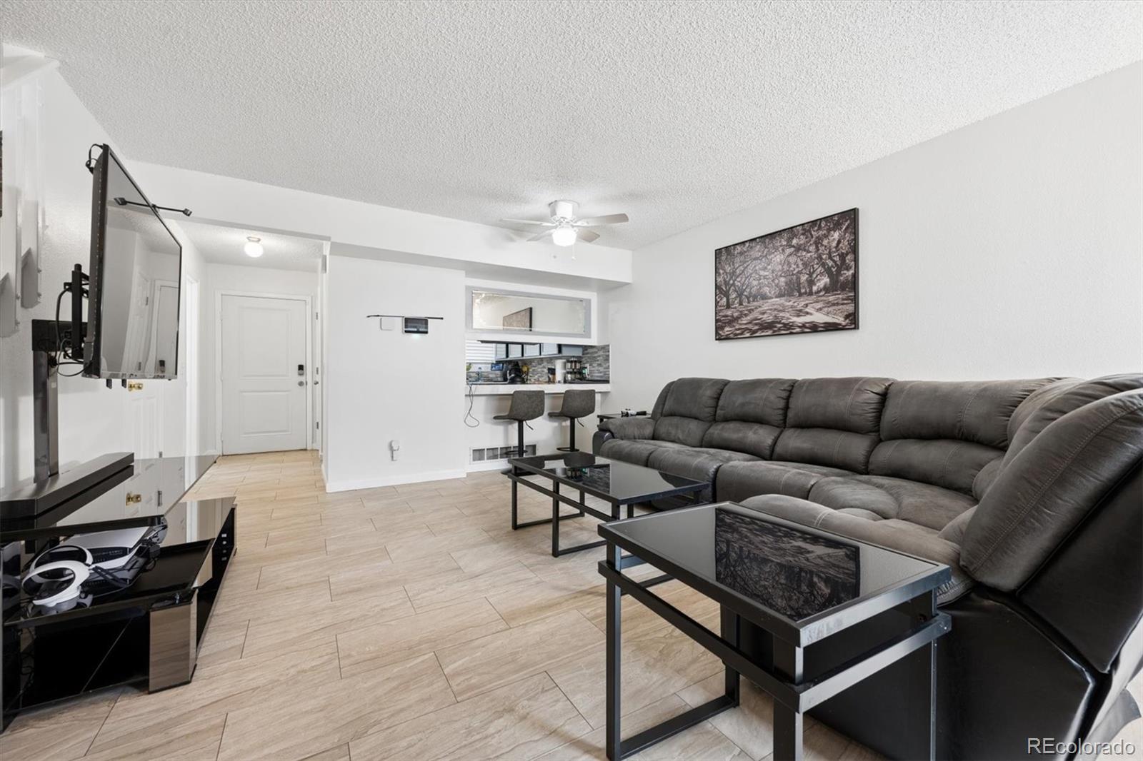 11688 East Cedar Avenue Aurora, CO 80012 - Photo 3 of 24 a living room with furniture and a flat screen tv