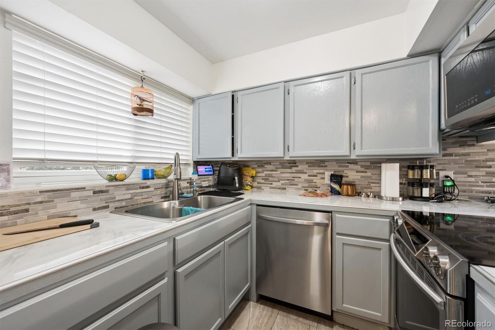 11688 East Cedar Avenue Aurora, CO 80012 - Photo 7 of 24 a kitchen with a sink stove top oven and cabinets