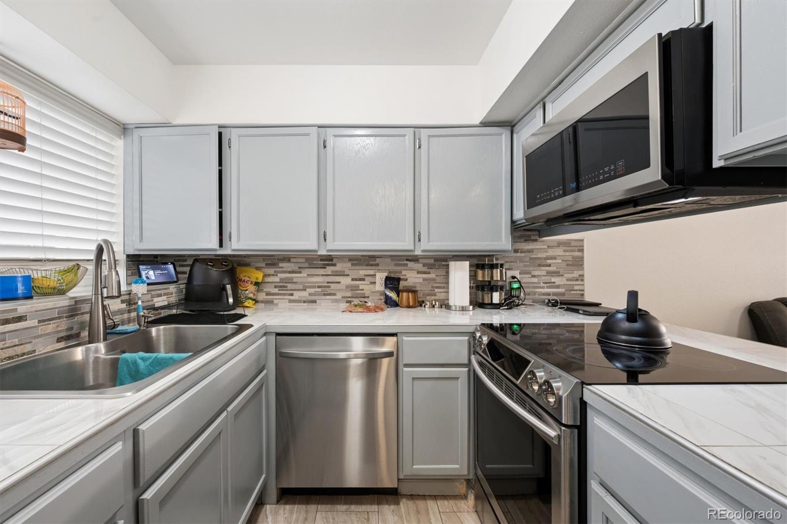 11688 East Cedar Avenue Aurora, CO 80012 - Photo 8 of 24 a kitchen with stainless steel appliances granite countertop a sink stove oven a sink and dishwasher with cabinets