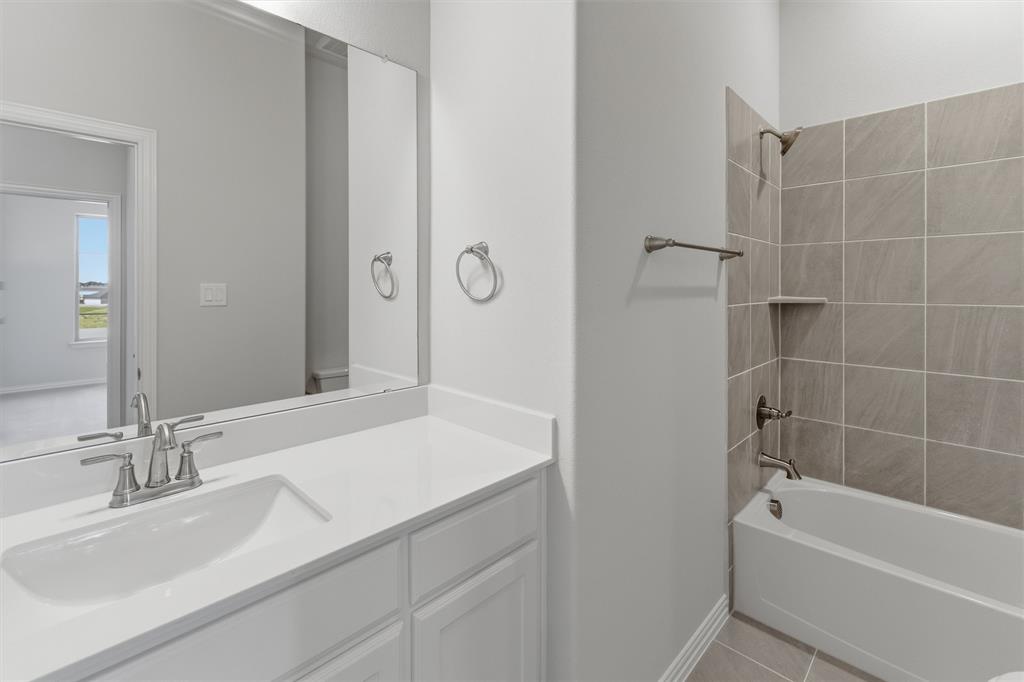 104 Snowy Owl Trail Rhome, TX 76078 - Photo 8 of 27 Bathroom featuring a vanity with a white countertop and an integrated sink, brushed nickel faucet, and a large wall-mounted mirror