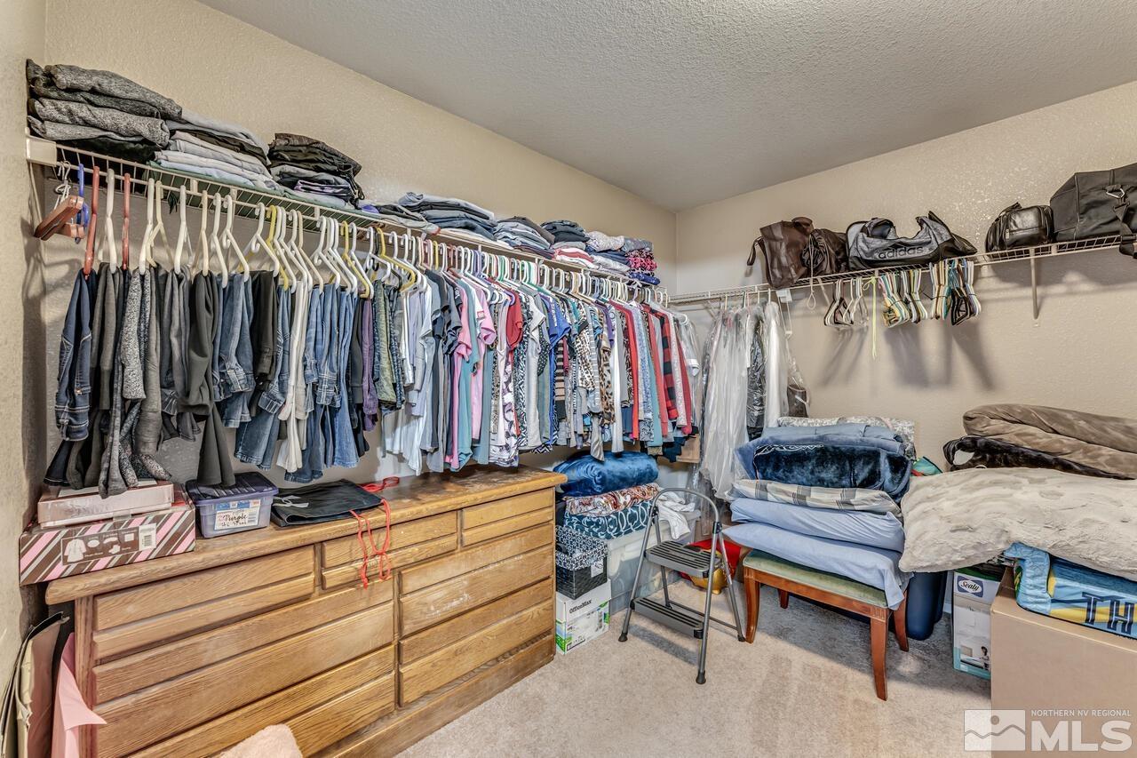 7699 Corso Street Reno, NV 89506 - Photo 21 of 36 a view of walk in closet with clothes and shoes