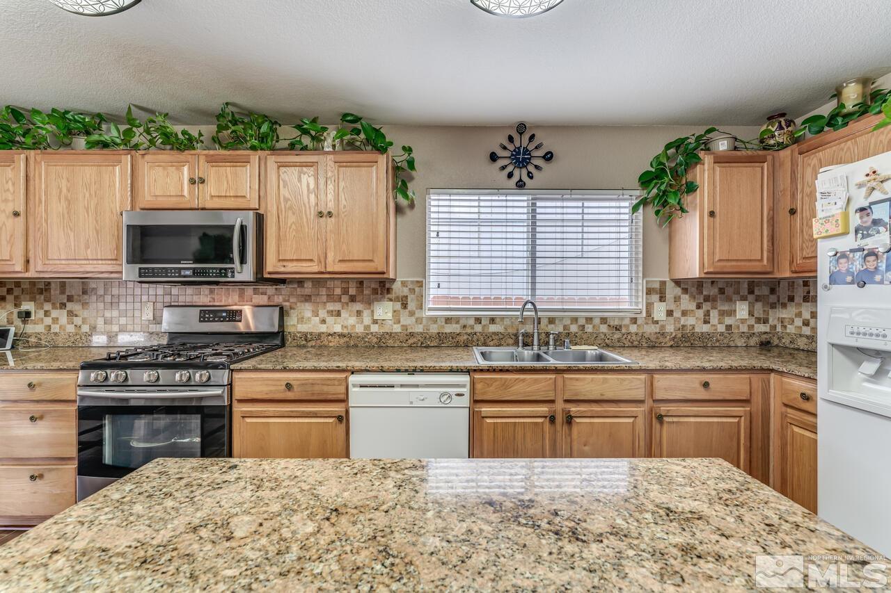 7699 Corso Street Reno, NV 89506 - Photo 8 of 36 a kitchen with a sink stove and microwave