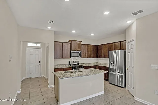 a kitchen with stainless steel appliances granite countertop a refrigerator and a sink