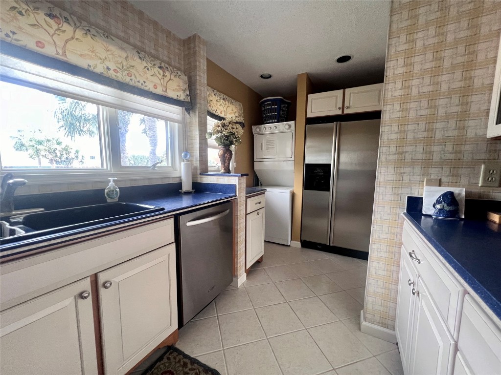 95116 Sandpiper Loop Fernandina Beach, FL 32034 - Photo 11 of 40 a kitchen with stainless steel appliances a sink dishwasher a refrigerator and white cabinets with wooden floor