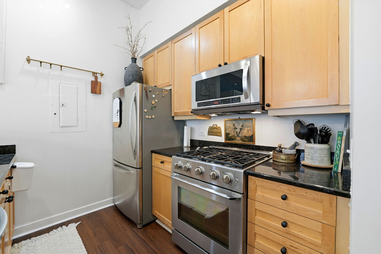949 West Madison Street, Unit 304 Chicago, IL 60607 - Photo 7 of 21 a kitchen with granite countertop cabinets stainless steel appliances and wooden floor