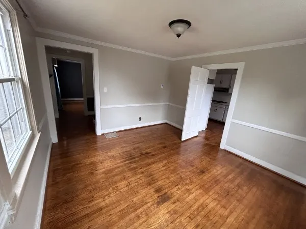 an empty room with wooden floor and entrance