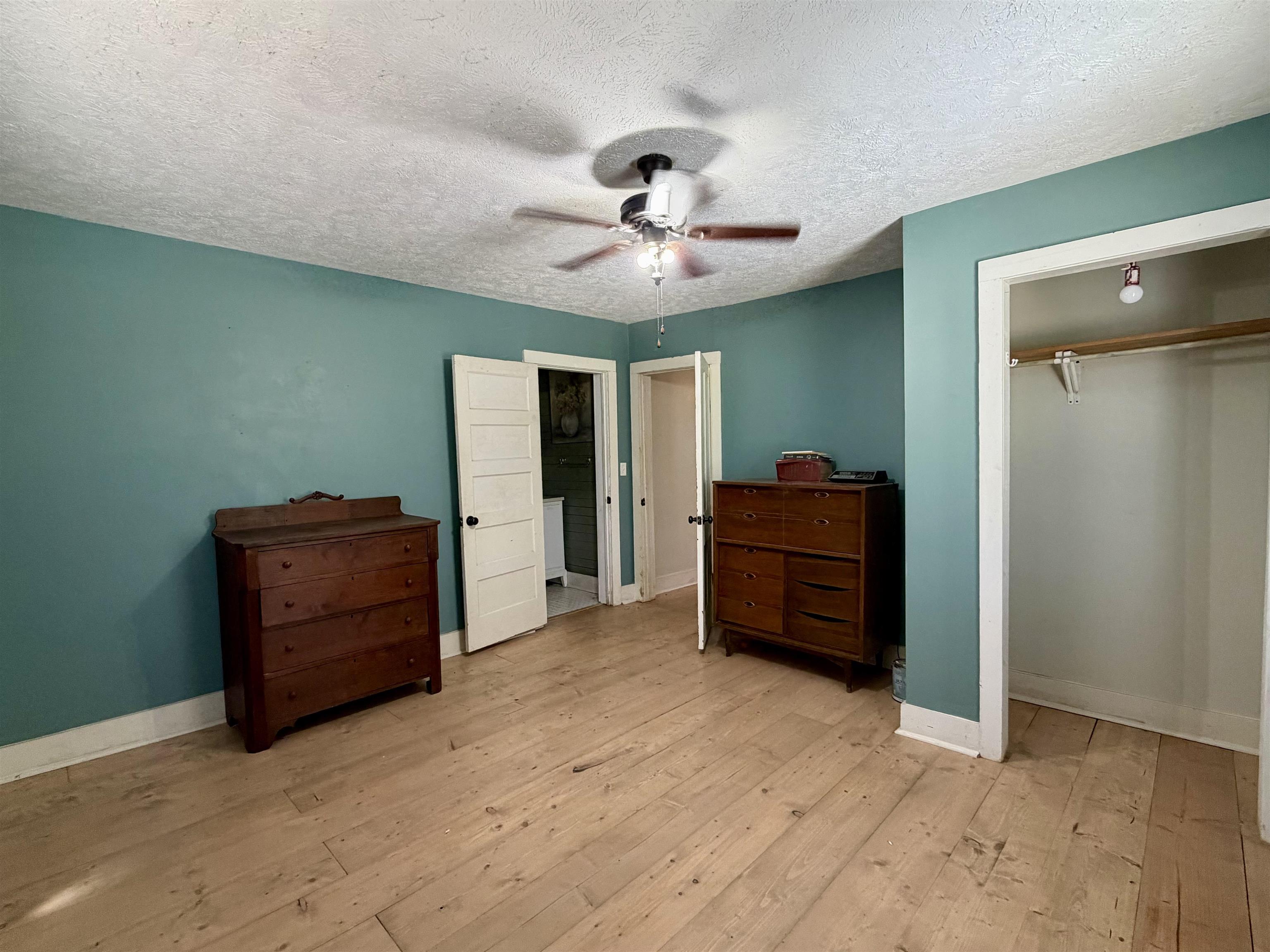 160 Chewalla Road Ramer, TN 38367 - Photo 17 of 39 Bedroom featuring light wood-style flooring, a ceiling fan, a closet, and a textured ceiling