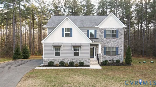 a view of a white house next to a yard with large trees