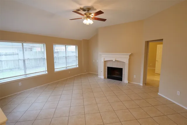 a view of an empty room with a fireplace and a window