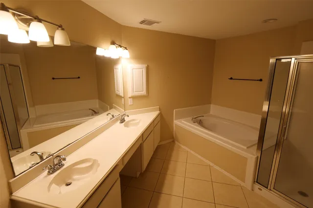 a bathroom with a tub sink and mirror