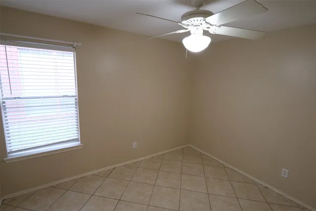 an empty room with a window and a fan