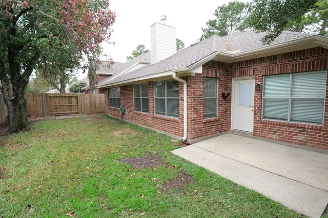 a view of a house with a yard and wooden fence